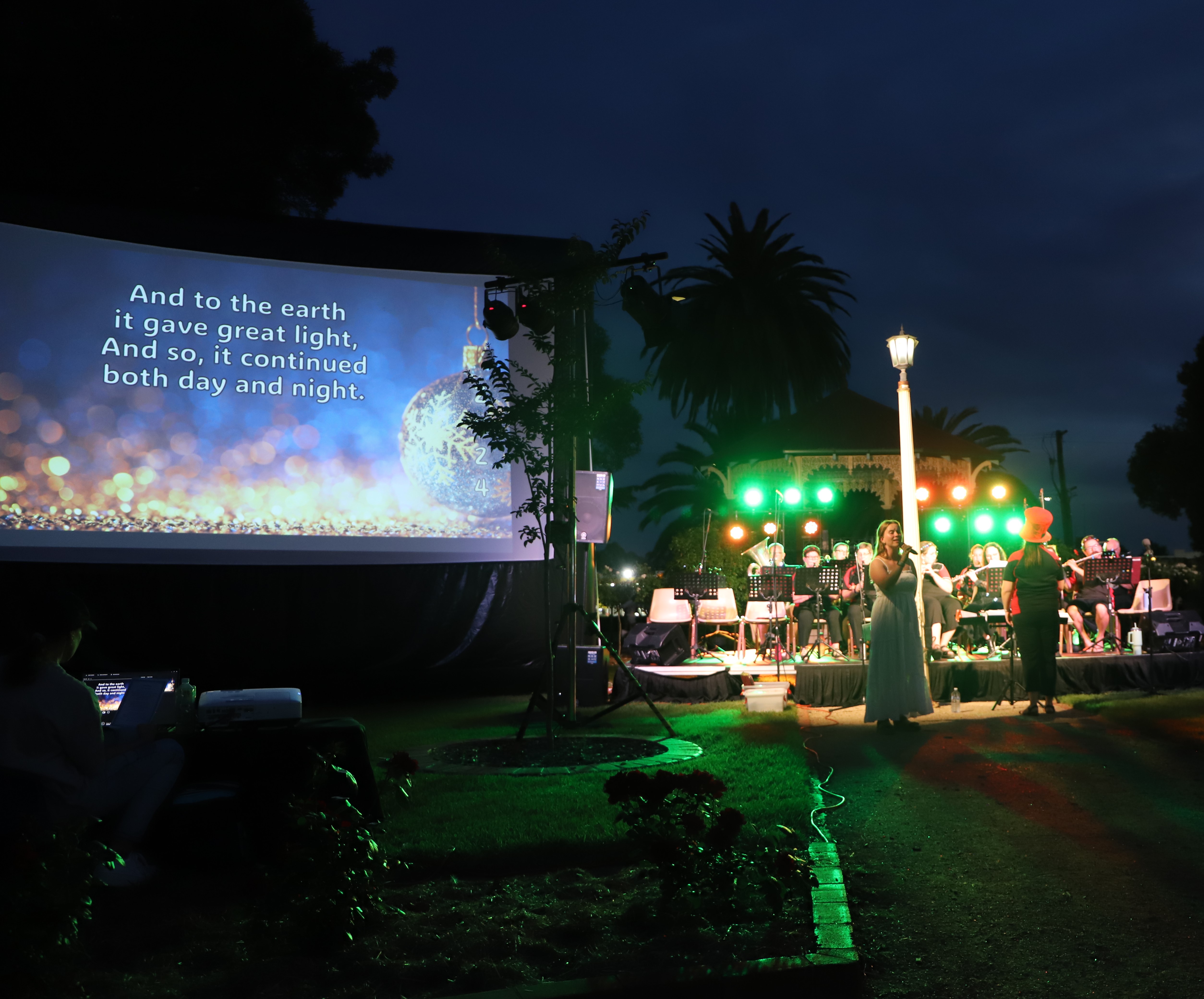 Woman singing Christmas carols at night